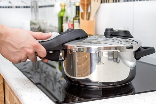 Holding a pressure pan in modern stove