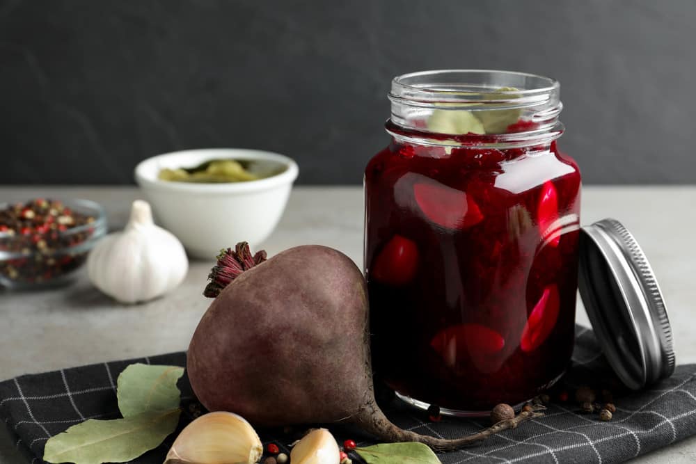 Pickled beets in glass jar on light table