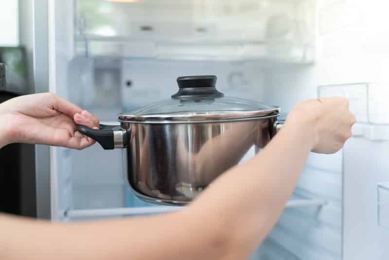 Hands Putting Pot Into refrigerator