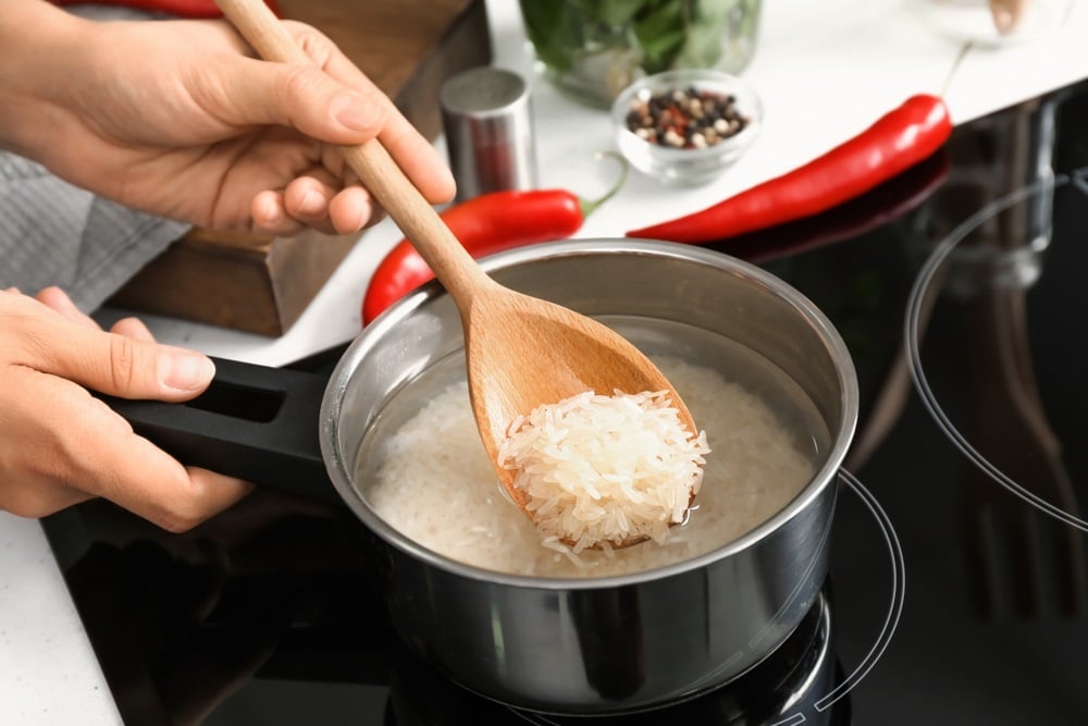 cooking rice in saucepan on stove