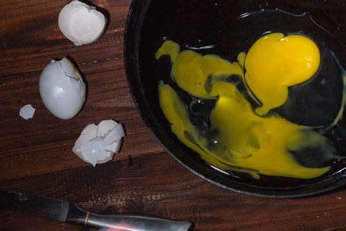 Broken egg yolk in a pan