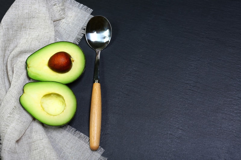 green avocados wooden spoon