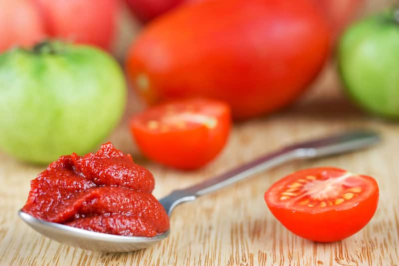 tomato paste spoon wooden background