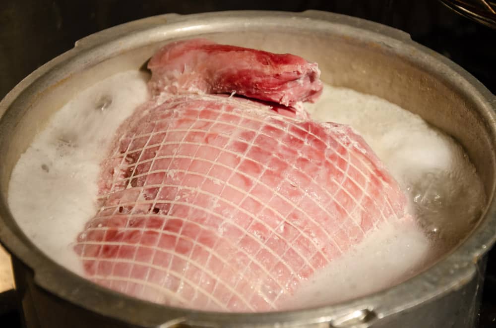 A joint of gammon boiling in a large pan