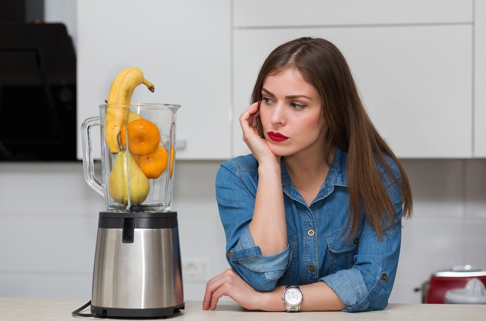 woman using blender at her kitchen