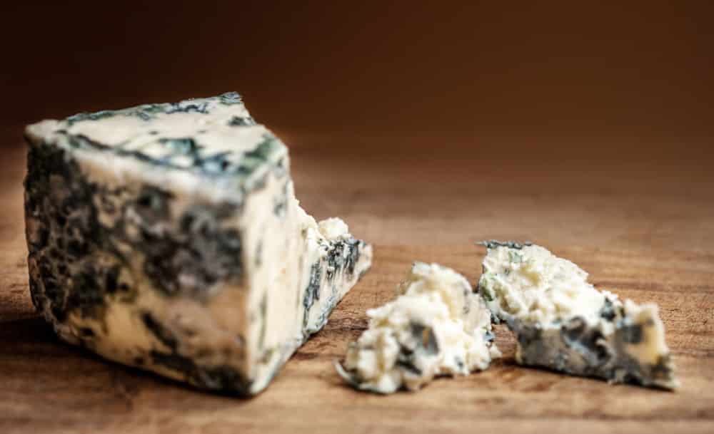 Blue cheese Gorgonzola on a rustic wooden background