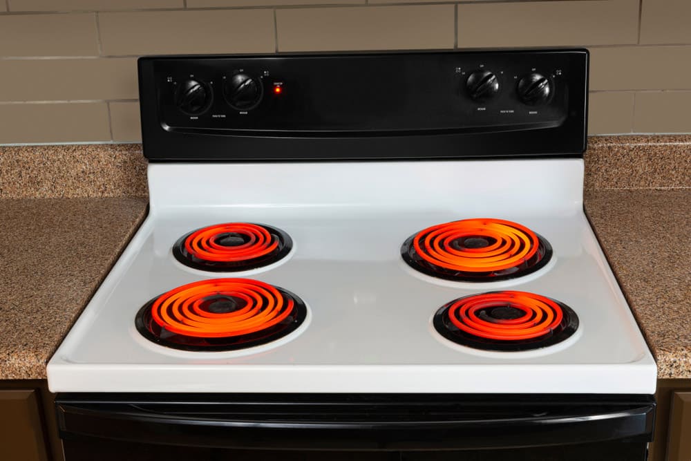 Horizontal shot of the stovetop of an electric range with all the burners turned