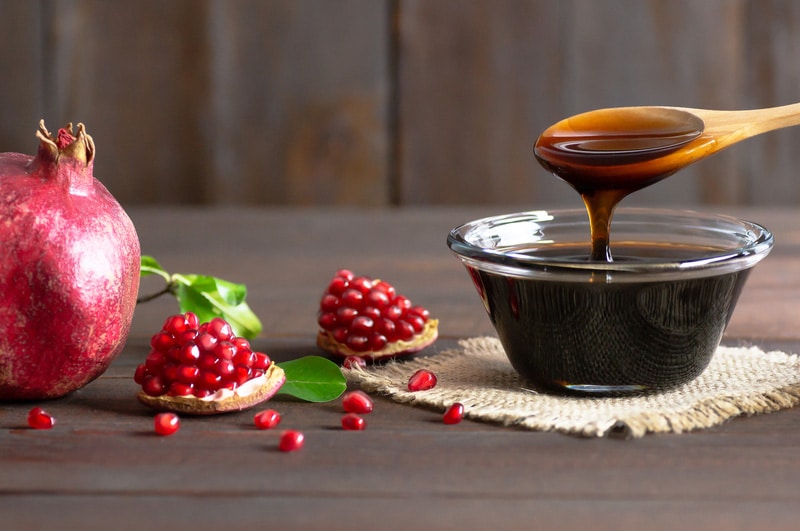 Pomegranate molasses in glass bowl Punica granatum