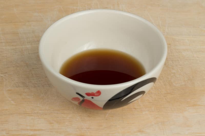 Isolated a bowl of fish sauce on the wood block