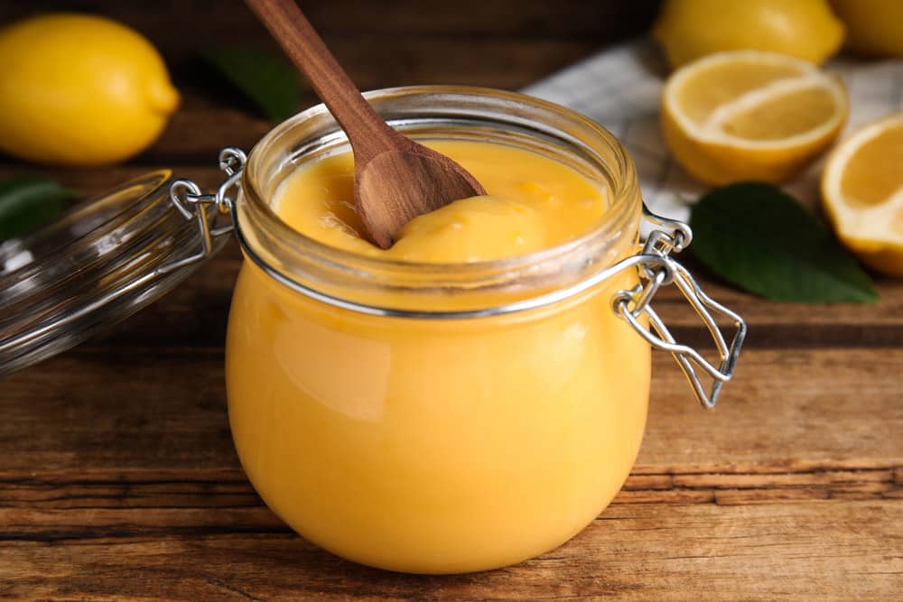 lemon curd in glass jar on wooden table