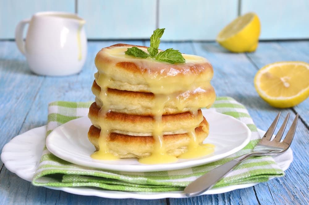 Pancakes with lemon sauce on a white plate