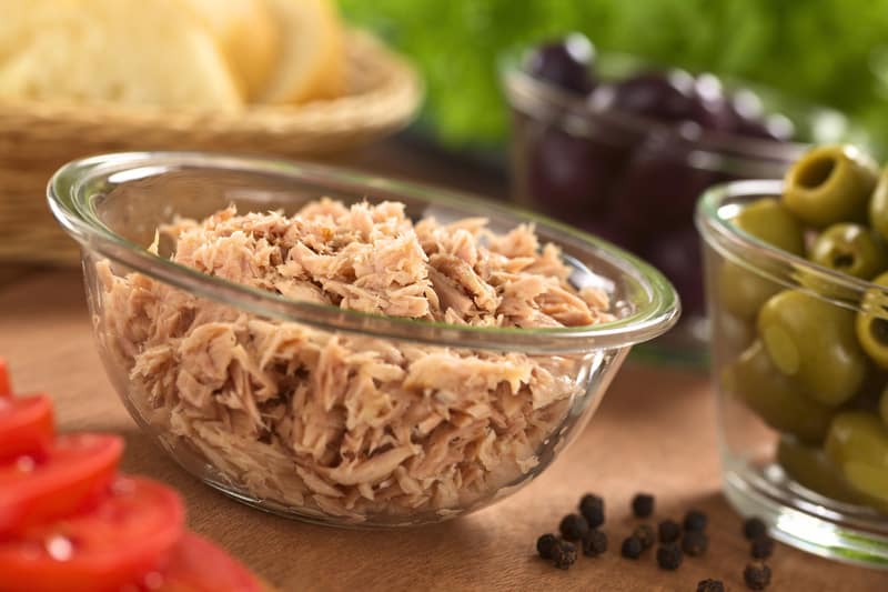 Canned tuna in glass bowl with fresh salad ingredients