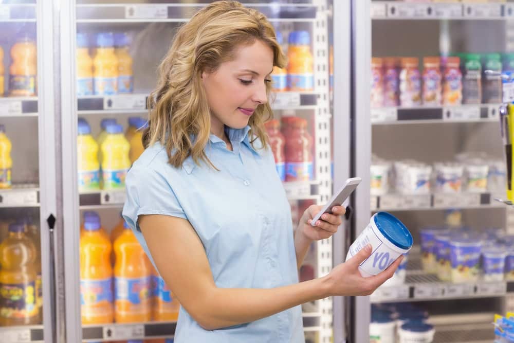  woman taking a picture of a cream cheese in supermarket