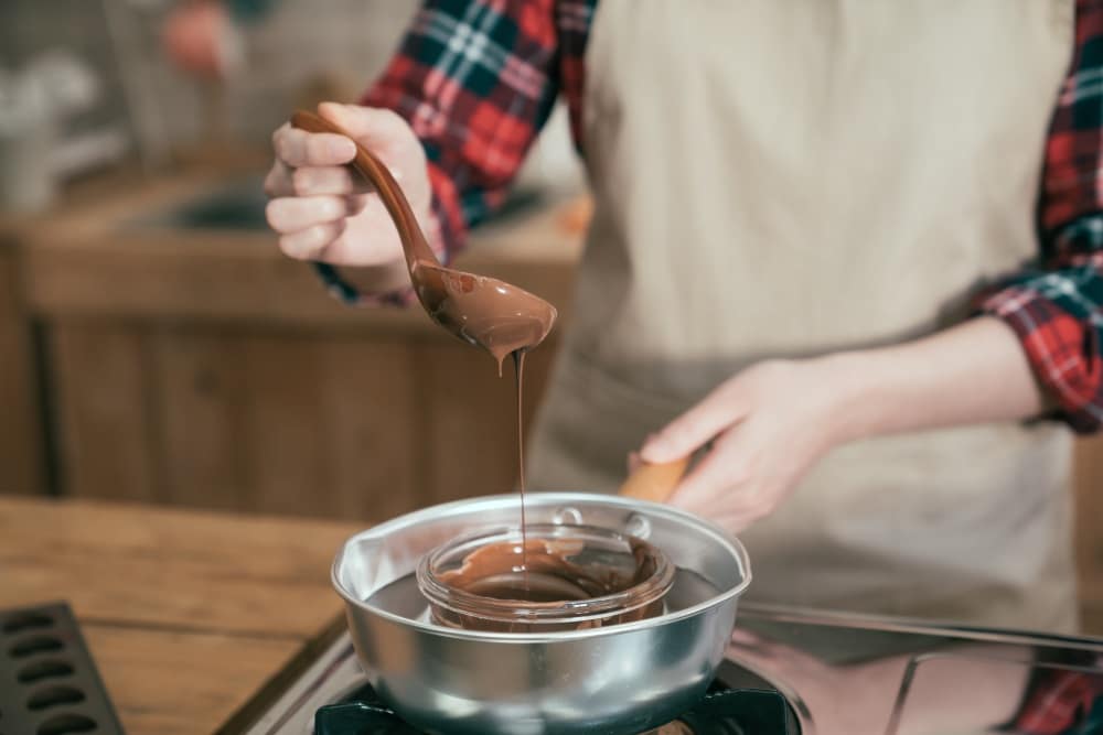 Fondue with melting chocolate in pot on stove