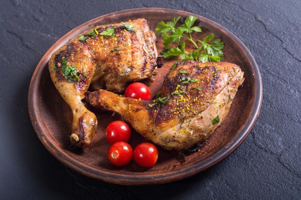 Grilled chicken legs with tomatoes and parsley