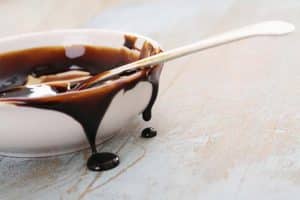 Treacle dripping from dish with spoon