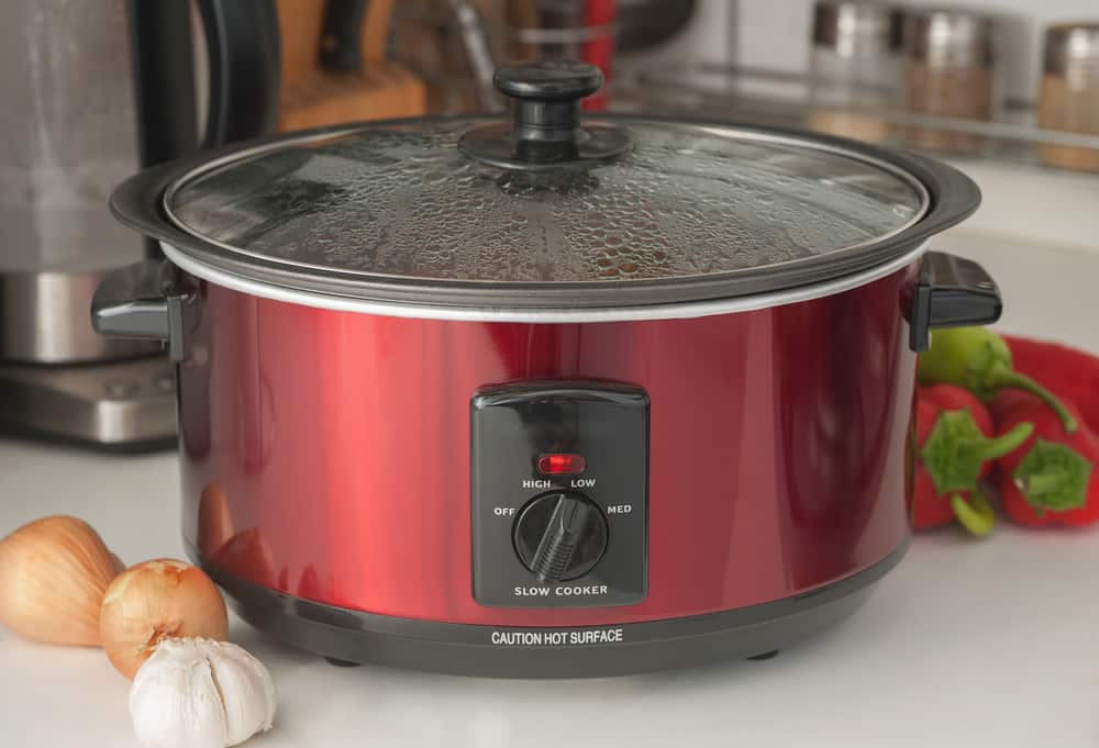 Close up of a slow cooker working on kitchen shelf