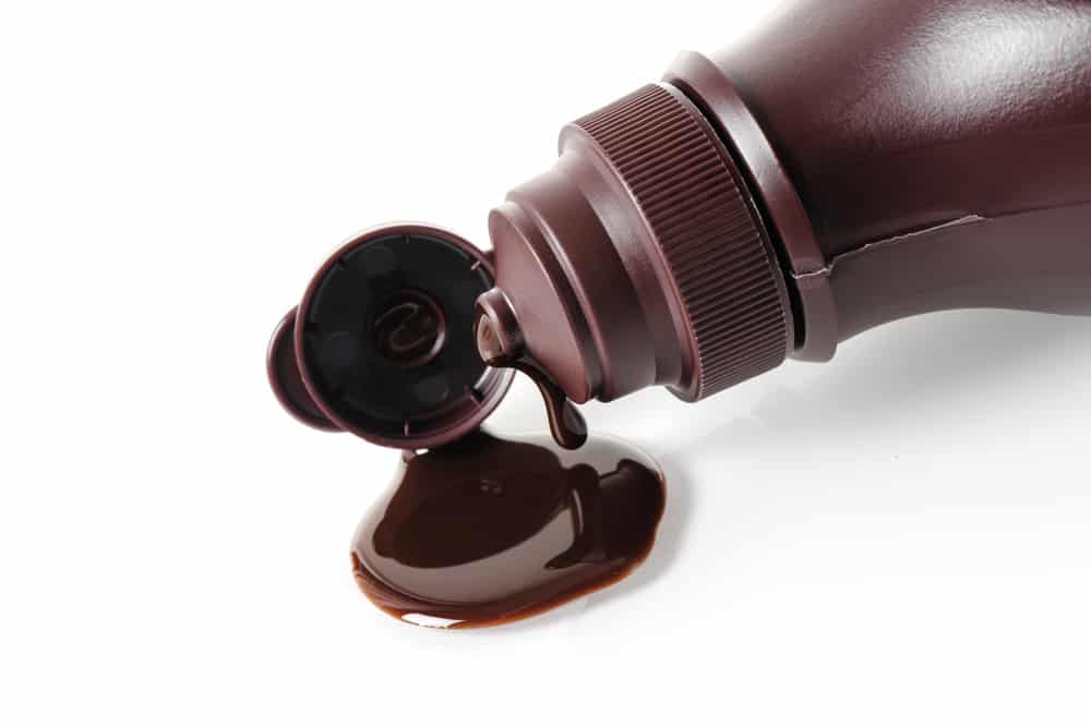 closeup chocolate syrup pouring on white background