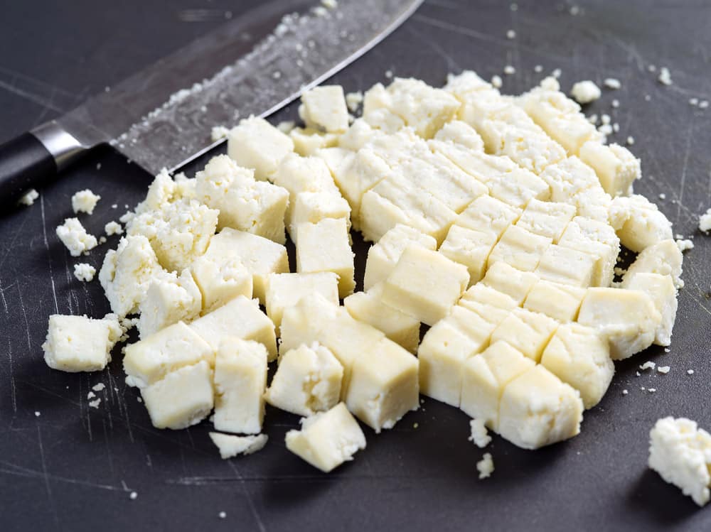 Photo of freshly cut Paneer cheese on a cutting board