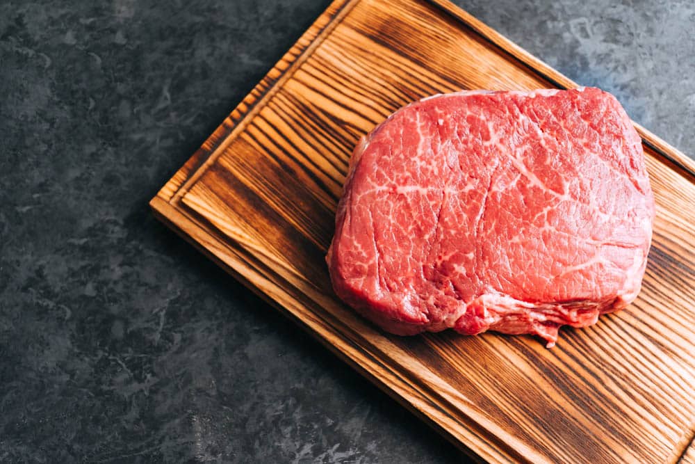 Raw beef steak on wooden board