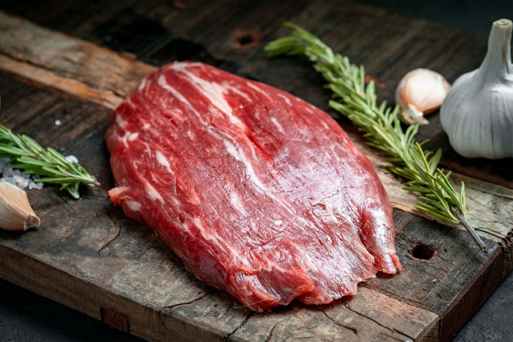 Raw flank beef steak and ingredients for cooking