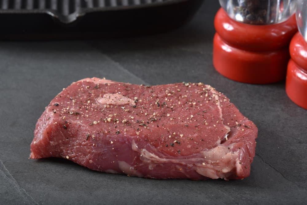 Raw top round steak with pepper