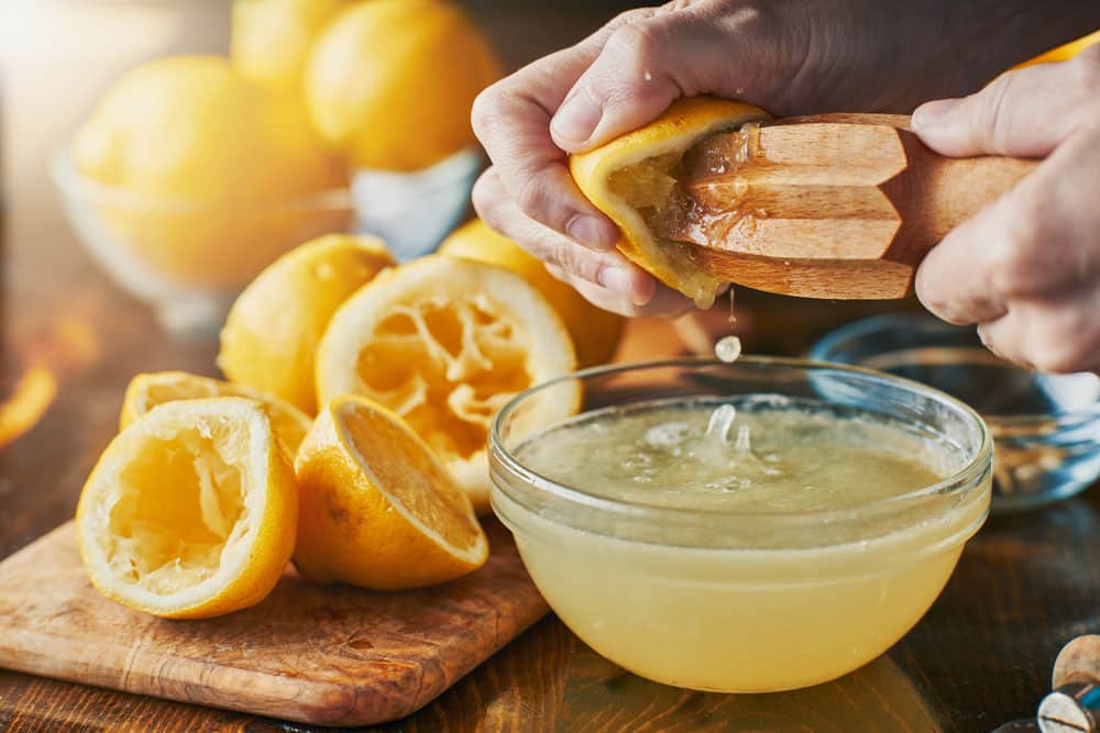 squeezing fresh lemon juice with wooden reamer