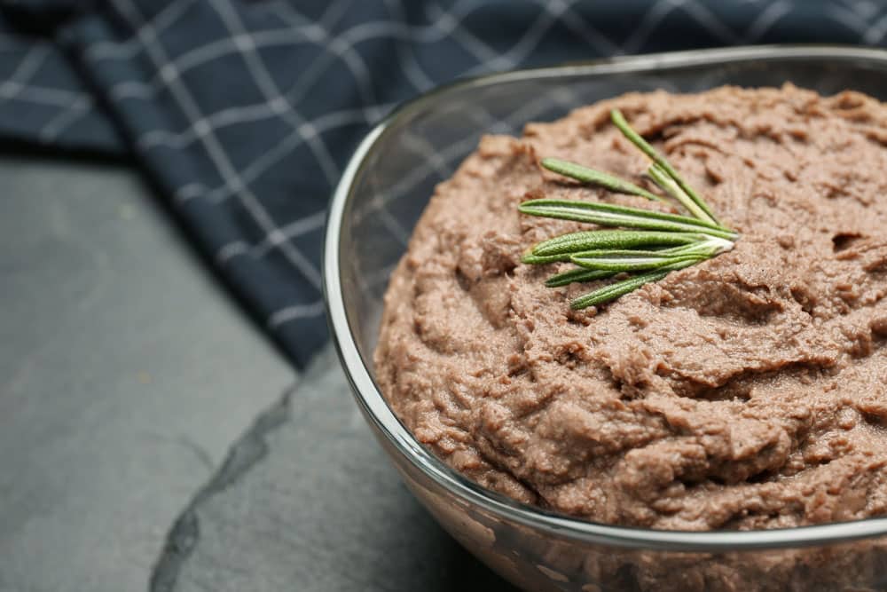 Tasty liver pate with rosemary in glass bowl