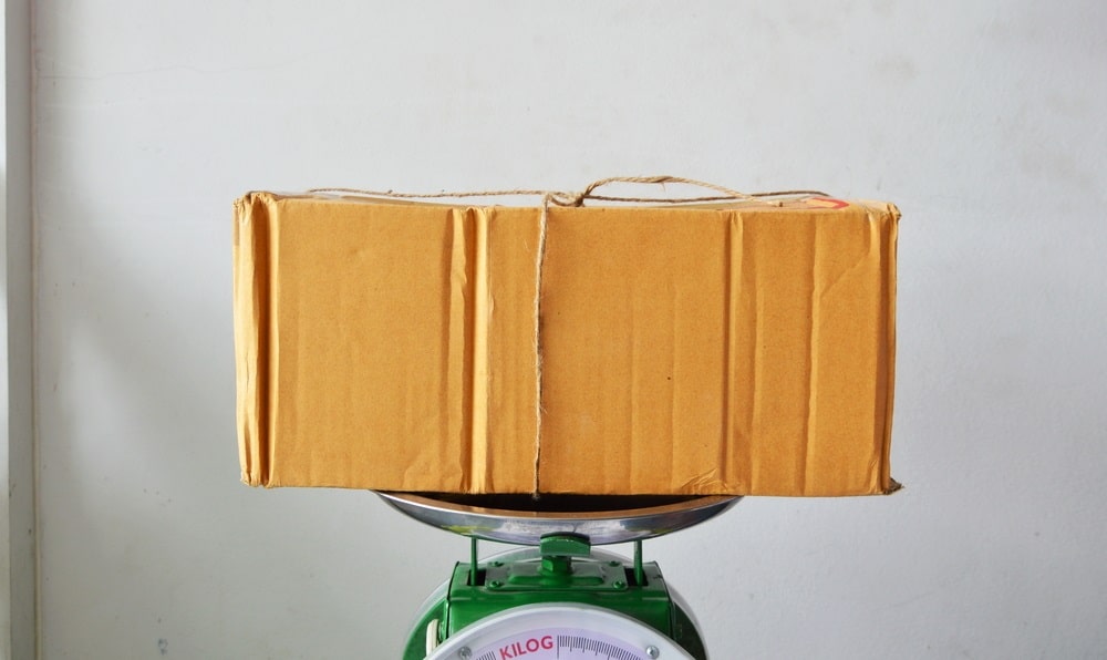 brown postal box on weighing scale