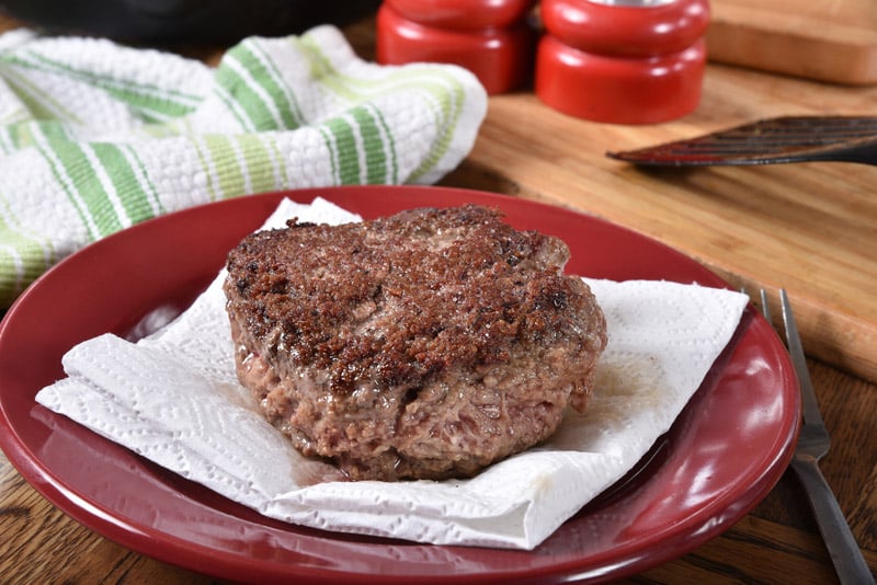 cooked hamburger thick being blotted paper towel