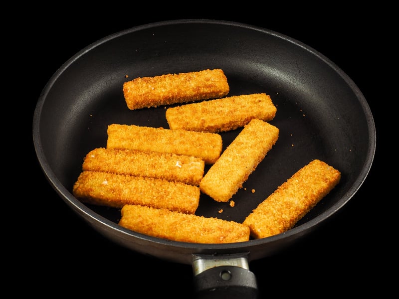 crumbed fish fingers fry pan