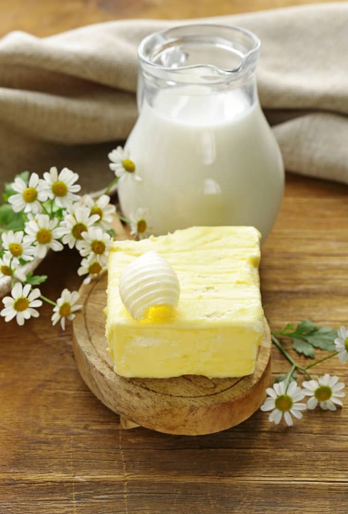 fresh yellow butter with a jug of milk