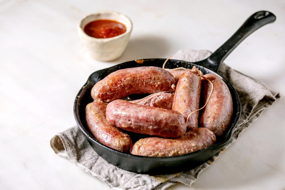 Grilled italian sausages salsiccia in cast-iron pan
