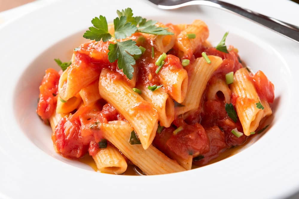 Plate of penne all'arrabbiata, a traditional recipe of spicy italian pasta