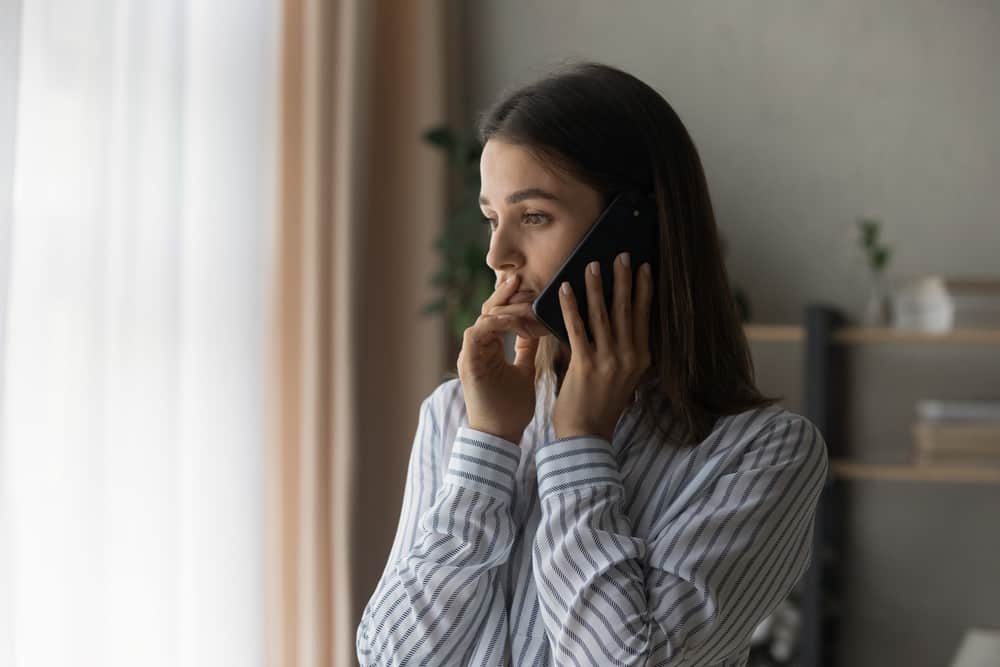 Sad millennial woman has difficult phone talk