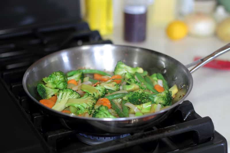 stir fry vegetables cooking stainless steel pan