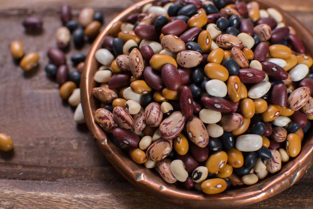 Variety of protein rich colorful raw dried beans on wooden table