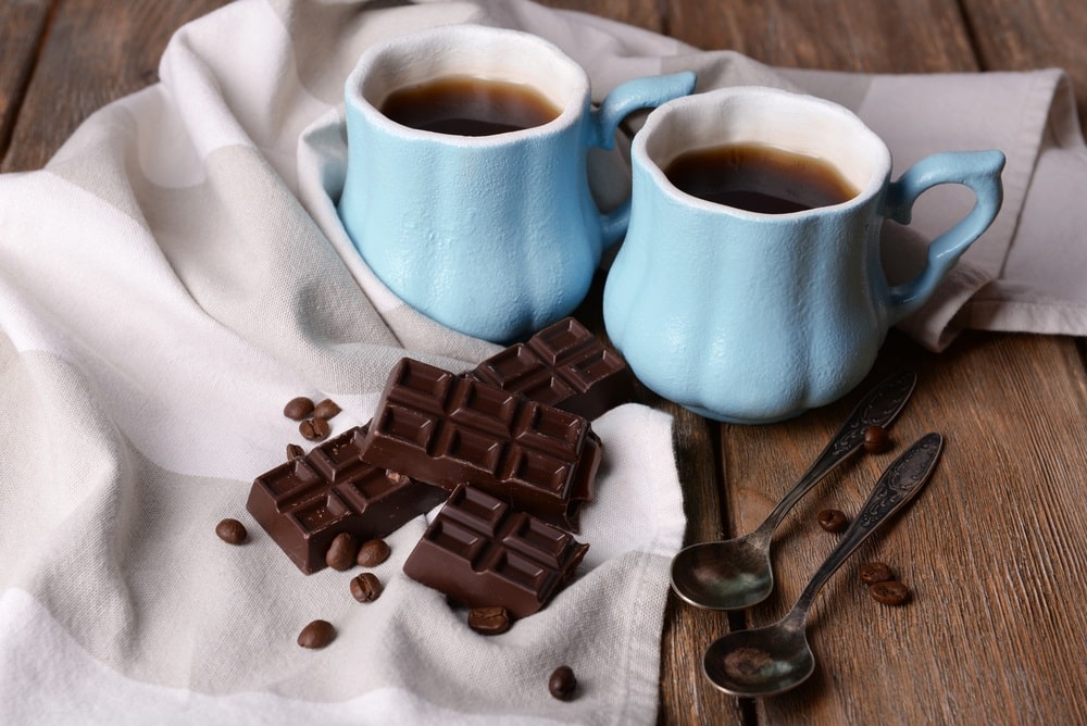 Cups of coffee with chocolate and napkin