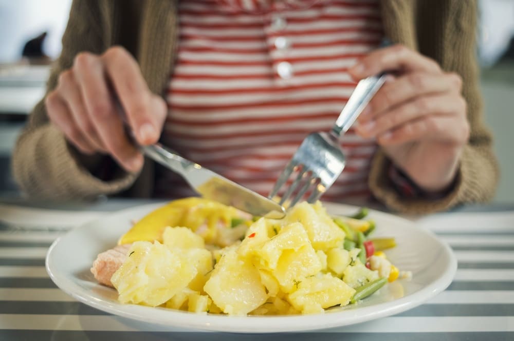 Woman Eating Fish And Potatoes