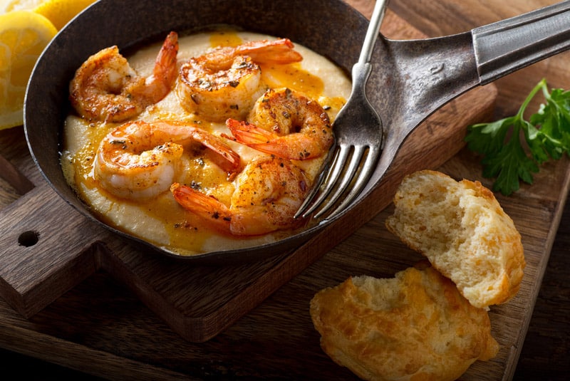 A pan of delicious fresh homemade cajun style shrimp and grits with cheddar biscuit