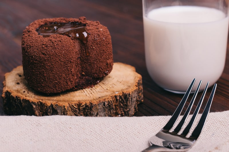 Chocolate cake and glass of milk on a brown table