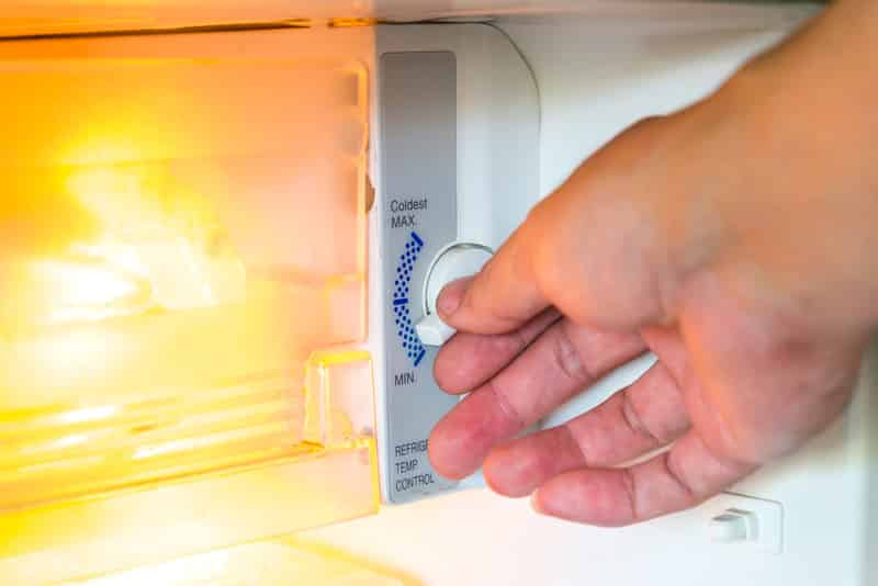 Close up hand of refrigerator`s temperature adjustment