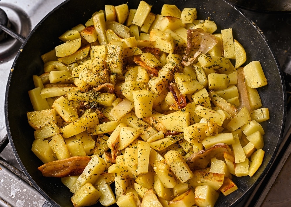 fried potatoes with bacon in a pan