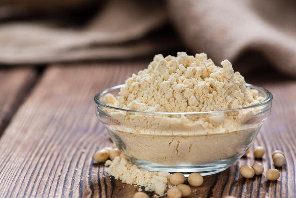 Heap of Soy Flour on rustic wooden table