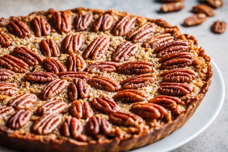 Whole pecan Pie on gray-brown background. Vegan dessert concept