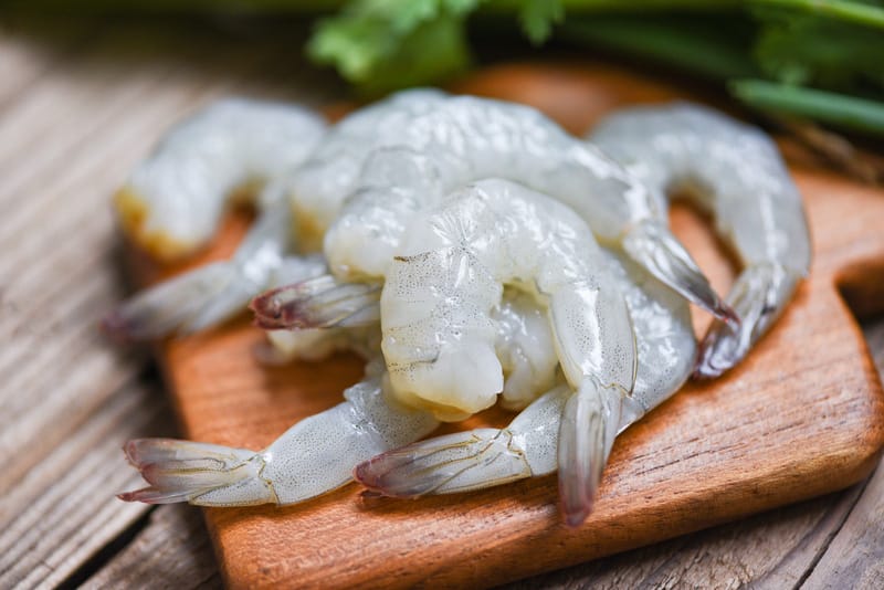 Raw shrimp on wooden cutting board background for cooking