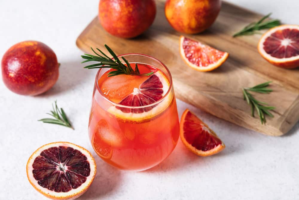 Delicious Blood Orange Cocktail on white table background