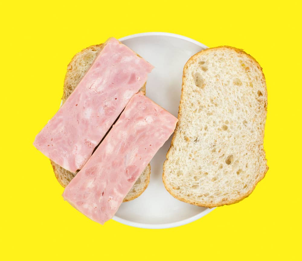 An opened faced processed ham sandwich with bread 