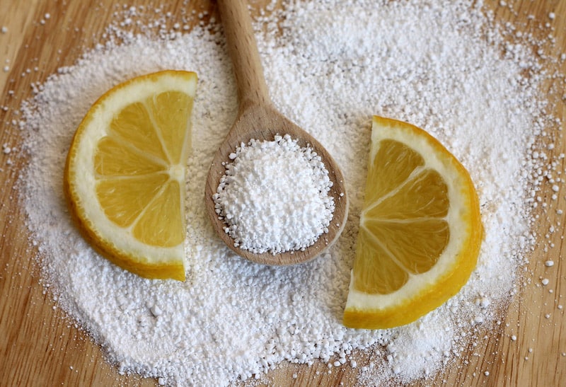 Citric acid in wooden spoon with lemon