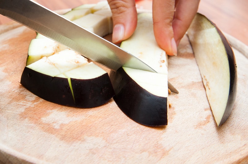 Cutting an eggplant on a wooden board